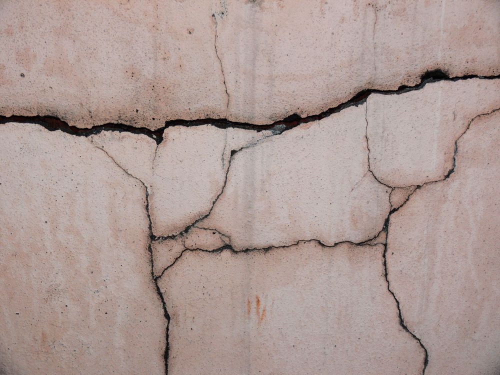 Muro di un edificio con crepe evidenti, simbolo di vulnerabilità sismica e danni da terremoto.